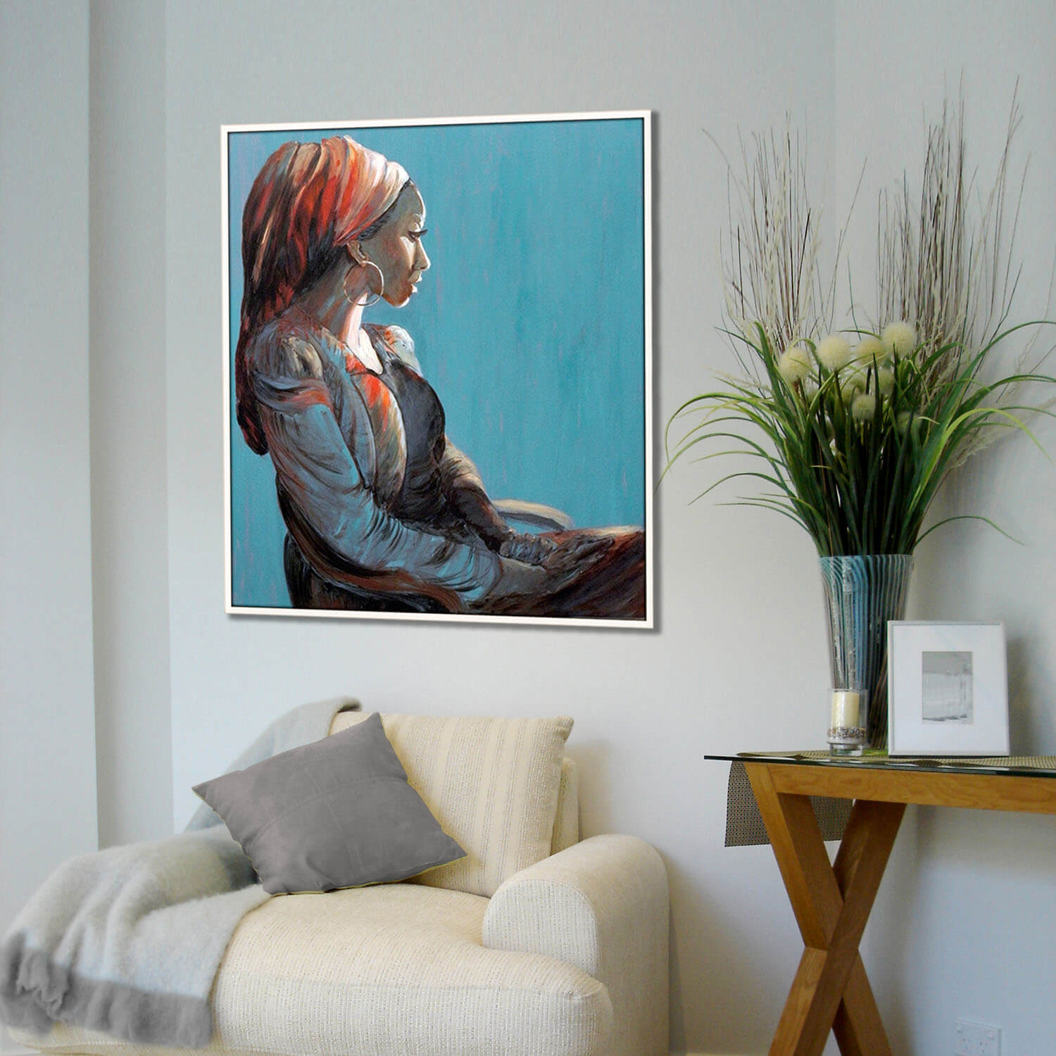 ציור אישה עם כיסוי ראש אדום יושבת על רקע כחול תמונה רגועה מעל הכורסא לבית ציירת מירי לביא