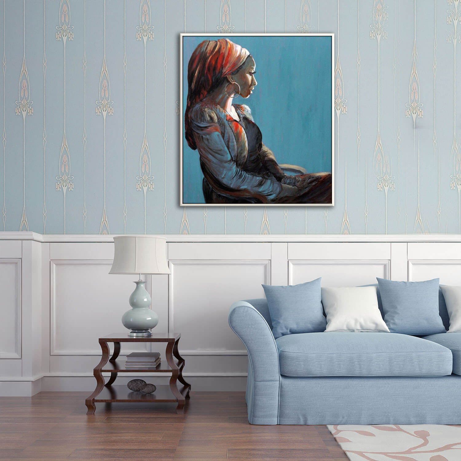 על רקע כחול ציור אישה עם כיסוי ראש אדום יושבת תמונה רגועה מעל הספה בסלון ציירת מירי לביא